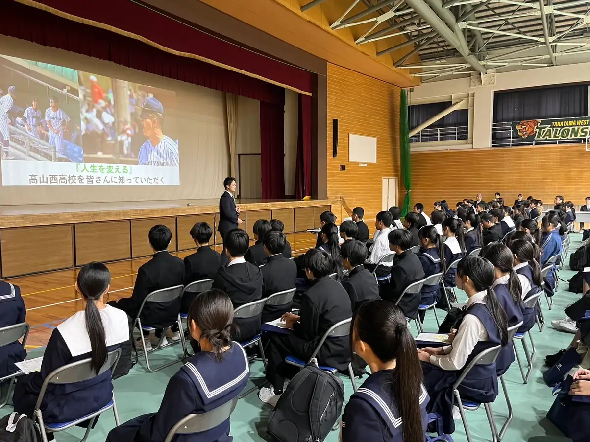 体育館で学校説明を聞く中学生