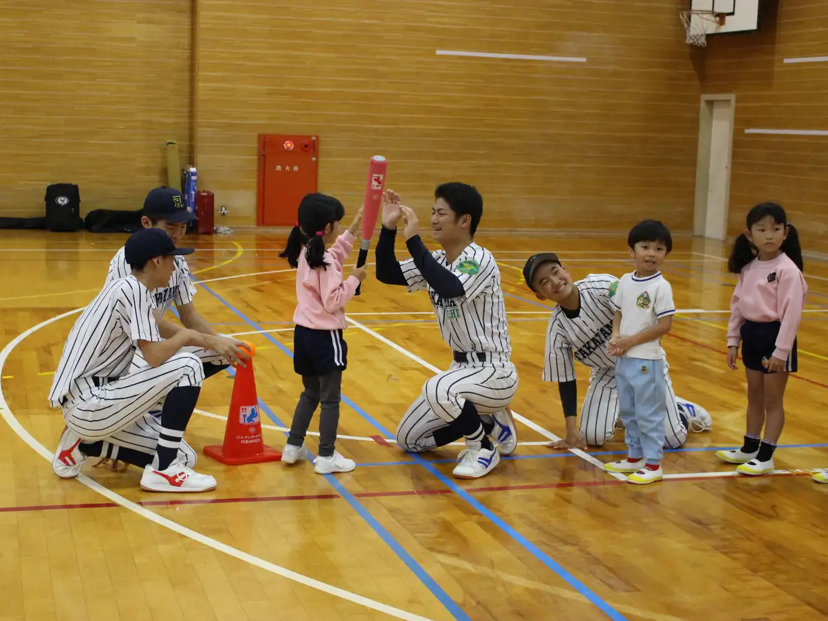 野球部員とハイタッチする園児
